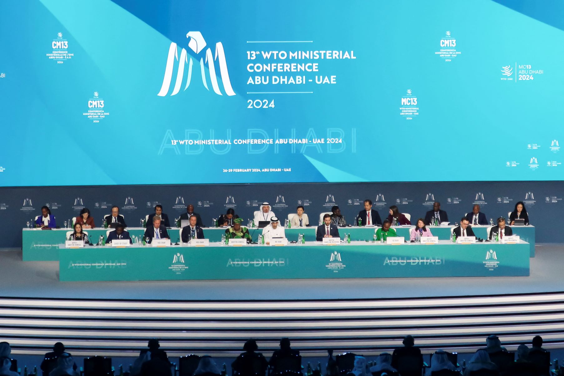 Delegates are seated on a platform on a large stage underneath a conference banner for the thirteenth World Trade Organization ministerial conference in Abu Dhabi, United Arab Emirates on February 26, 2024. REUTERS/Abdel Hadi Ramahi